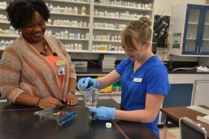 Dr. Erica Fleming working with a student in the Pharmacy lab