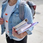 college student holding several text books