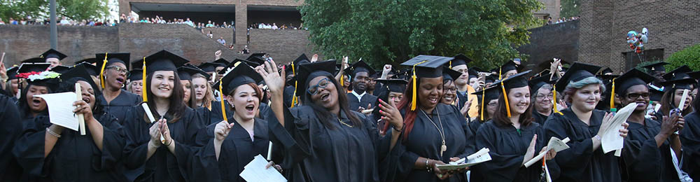 graduation group celebrating their success in black gowns