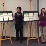 Four pharmacy students beside their white paper displays