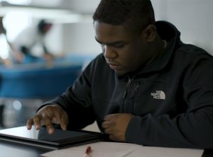 Student in class working on an electronic tablet
