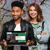 Two students holding a lap top
