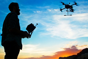 shillohette of a man flying a drone.