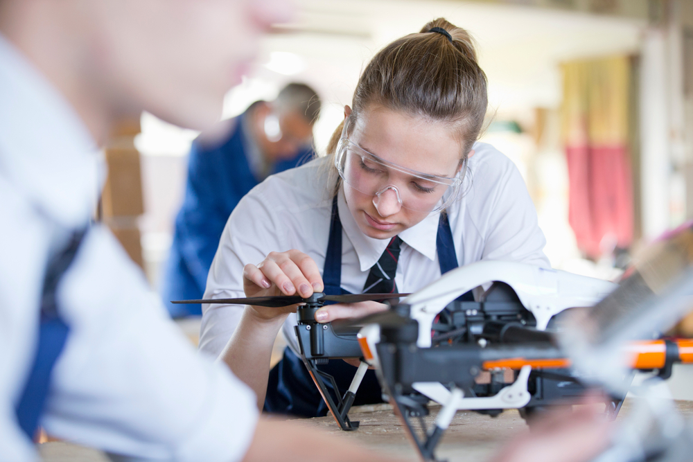 teenage girl assembling a drone.