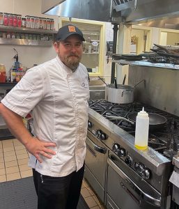 Sous chef Brandon Schultek smiling in a kitchen