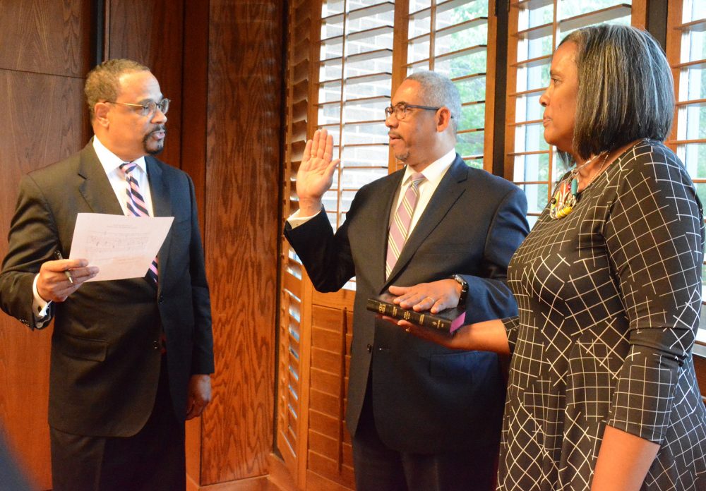 new board member being sworn in with wife.