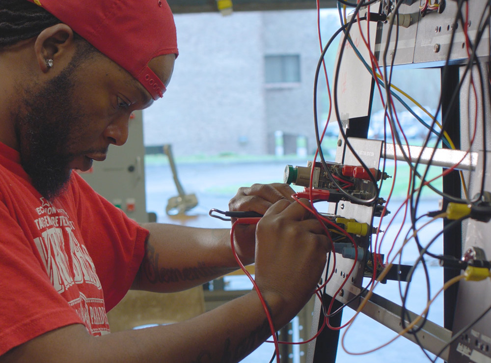 Electrical systems student working on a wiring board