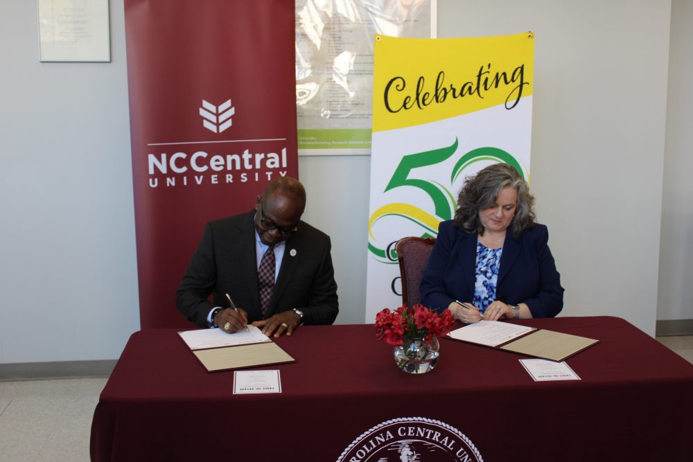 Presidents from both schools sign documents