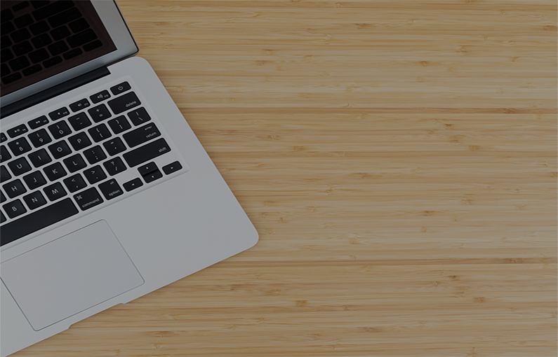 A picture of an open laptop lying on a wooden background.