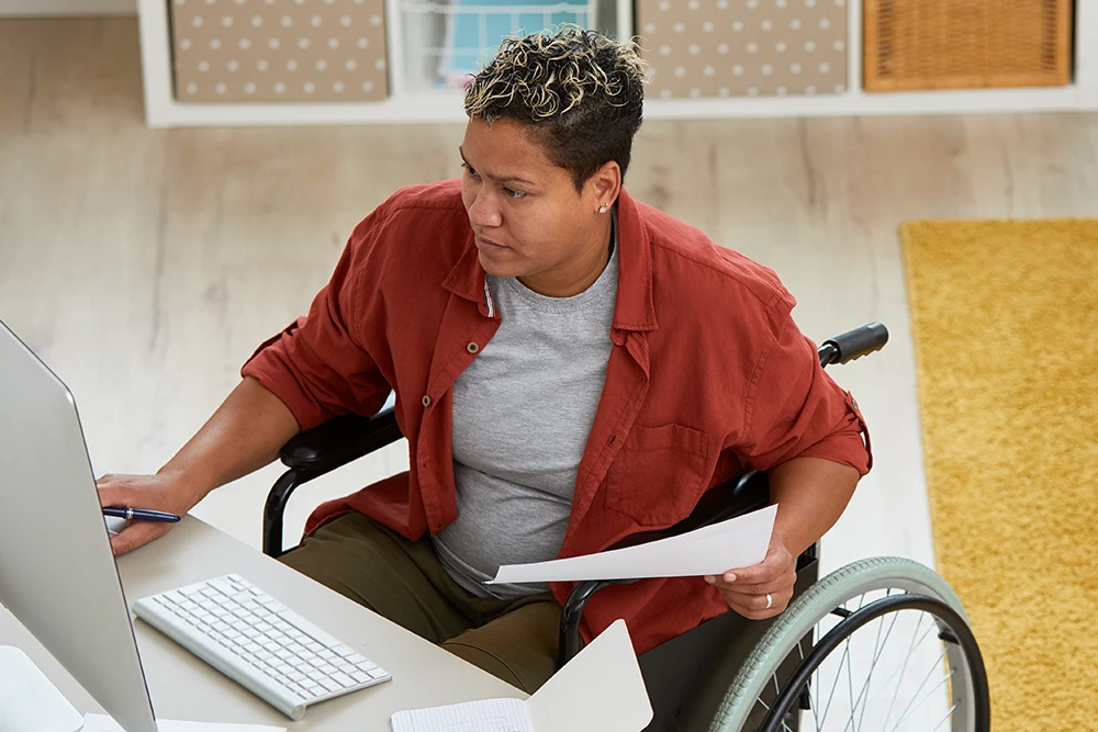 A woman in a wheelchair working on her computer.