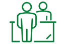 Clipart of two people standing with a desk between them.