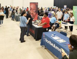 Students talking to recruiters from Revlon at a busy career fair.