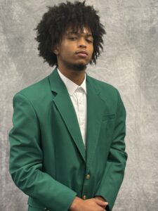 Darias Slankard wearing a green VGCC Ambassadors coat.