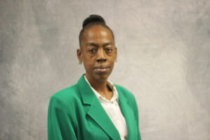 Suquana Charley wearing a green VGCC Ambassadors coat.