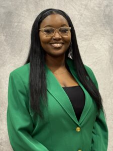 Taylor Page wearing a green VGCC Ambassadors coat.